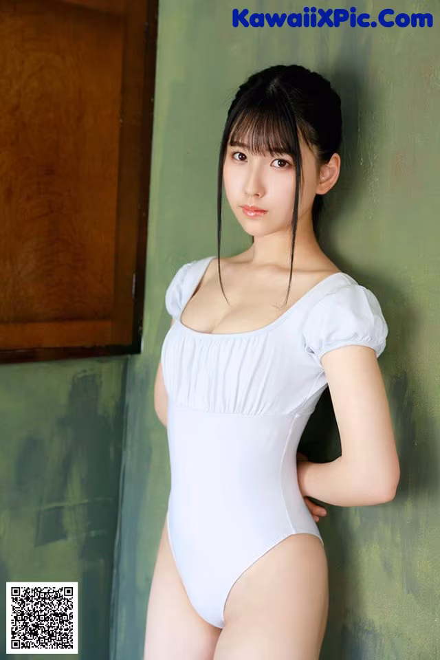 A woman in a white bodysuit posing for a picture.