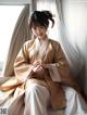 A woman in a kimono sitting on a window sill.