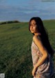 A woman standing in a field of green grass.