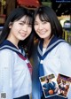 A couple of young women in school uniforms posing for a picture.