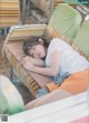 A young woman laying on a couch with her head on a pillow.