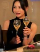 A woman sitting at a table with two glasses of wine.