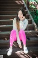 A young woman sitting on the steps of a building.