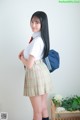 A woman in a school uniform with a backpack.