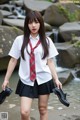 A woman in a school uniform is holding a pair of shoes.