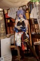 A woman dressed in a cosplay costume holding a book.